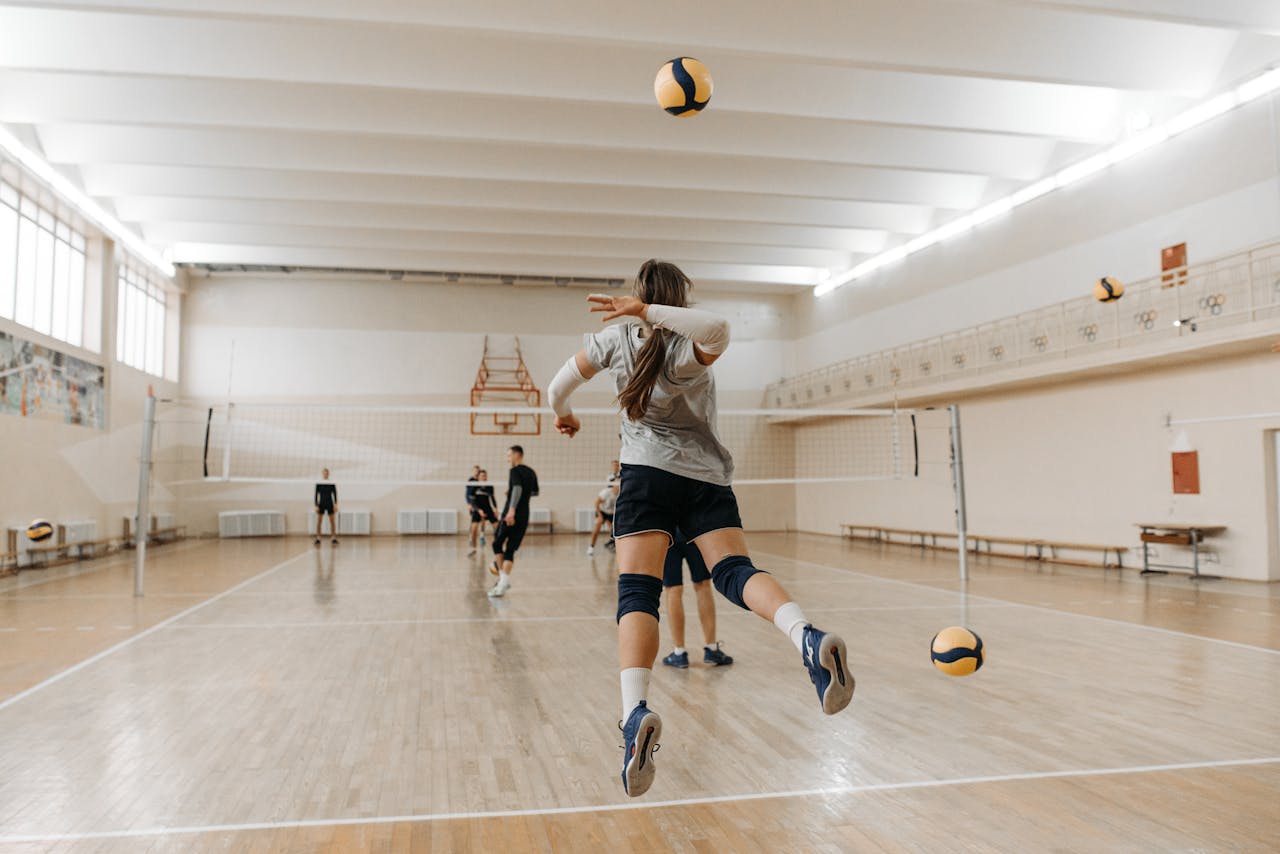 gallery-1 A dynamic volleyball match taking place in an indoor sports hall with players engaging actively.